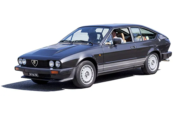 A black Alfa Romeo GTV6 is being driven by a family.