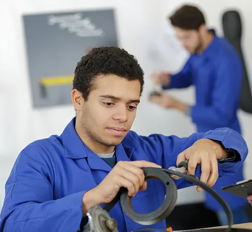 A trio of mechanics working together to repair a vehicle