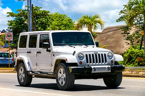 A white Jeep Wrangler on the road