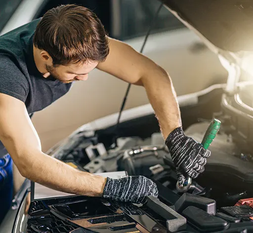 A professional auto mechanic working under the hood of a car