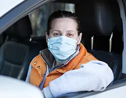 A female driver wearing a face mask to protect herself from air pollution