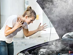 A surprised woman looking into her car's overheating problem