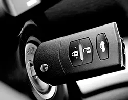 A black car key locked into a car's ignition switch