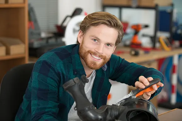 A professional mechanic in a workshop while gripping pliers