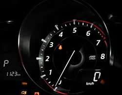 A car's tachometer indicates it travels at zero revolutions per minute.