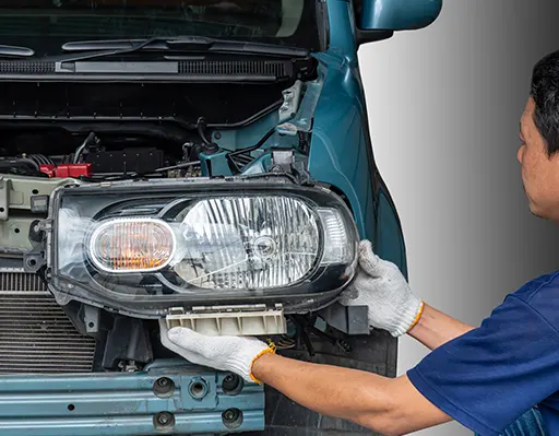 A professional car technician replacing a car's headlights