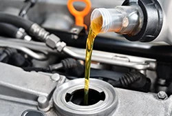 Pouring fresh motor oil into a car's engine