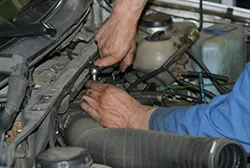A mechanic performing a tune-up on a car's engine