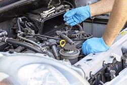 A technician working on spark plug and ignition coil replacement